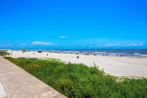 a beach with people on the sand and the ocean at Quality Inn & Suites Galveston - Beachfront in Galveston