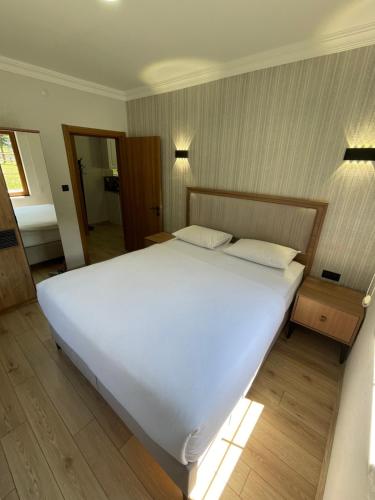 a large white bed in a bedroom with two pillows at Raha Villa Bungalow in Uzungol