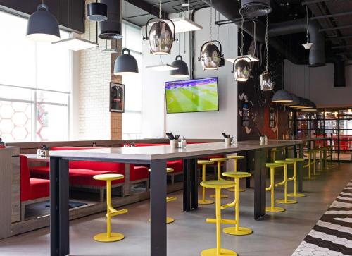 a bar with yellow and red bar stools at Radisson RED Dubai Silicon Oasis in Dubai
