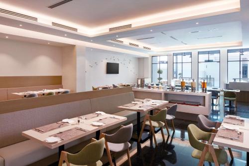 a restaurant with tables and chairs and a bar at Hilton Garden Inn Puchong in Puchong