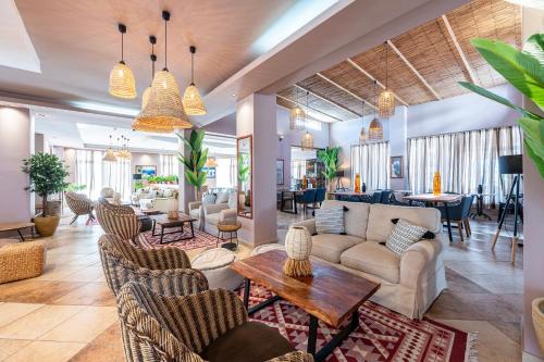 a living room with couches and chairs and tables at Aegean Bay Hotel in Kos Town