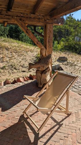 a chair sitting on a patio with a statue at Król Puszczy - unikatowy dom, jezioro 80m, szlak Krutyni in Ruciane-Nida