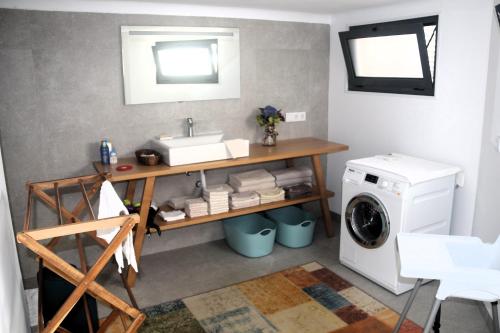 a bathroom with a sink and a washing machine at Apartamento tranquilo e acolhedor in Ponta Delgada