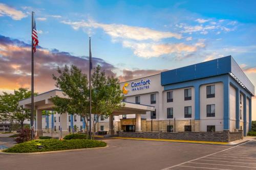 a building with an american flag in a parking lot at Comfort Inn & Suites Rapid City near Mt Rushmore in Rapid City