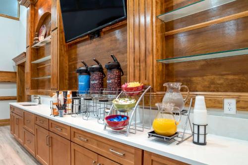 Eine Küchentheke mit Schüsseln voller Essen und Saft in der Unterkunft Comfort Inn Pensacola near NAS Corry Station in Pensacola