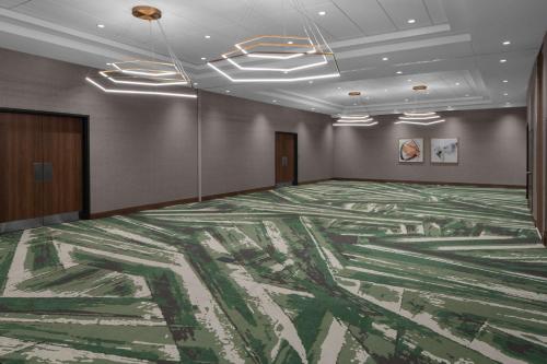 a large room with a green carpet on the wall at Embassy Suites By Hilton Madison Downtown in Madison