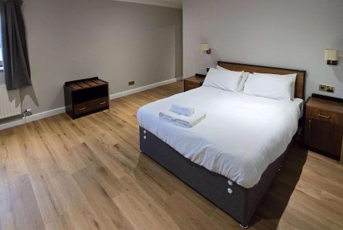 a bedroom with a large bed with white sheets at Staindrop Hotel in Sheffield