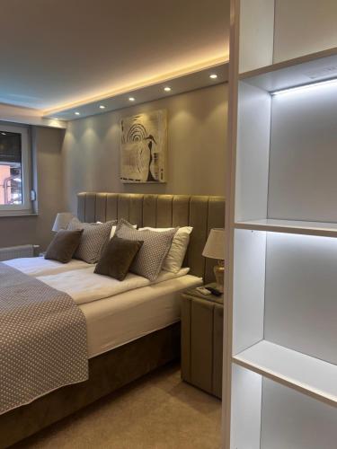 a bedroom with a bed with white sheets and pillows at Merdan Sarajevo in Sarajevo