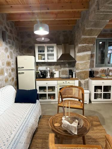 a kitchen with a couch and a table and a refrigerator at Nisyros Nest in Nikiá