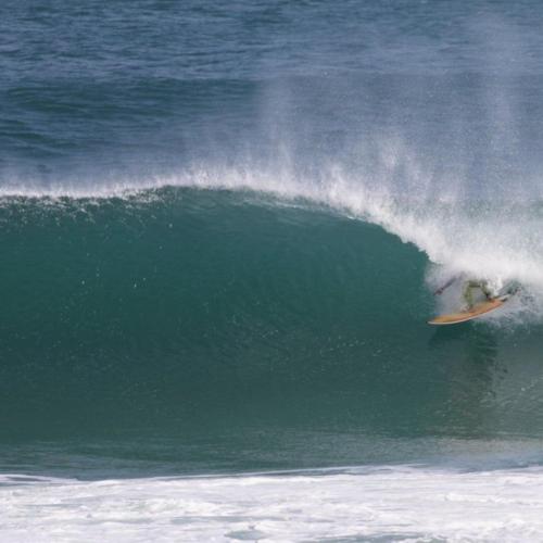 a person riding a wave on a surfboard in the ocean at Bienvenido Cozy Madiha in Matara