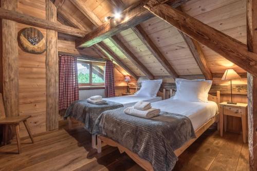 deux lits dans une chambre aux murs en bois dans l'établissement Le Gite - L'oréade - 6 pax, à Saint-Gervais-les-Bains