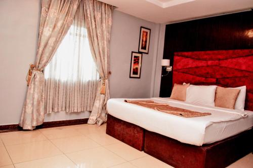 a bedroom with a large bed and a window at Danag Apartments in Port Harcourt