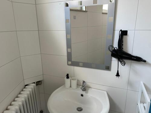 a bathroom with a sink and a mirror and radiator at Appartement for Rent 03 in Pattensen
