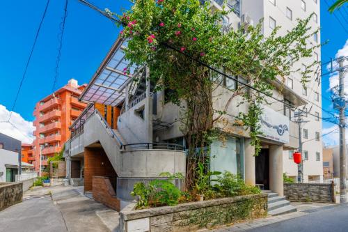 a building with flowers on the side of it at 国際通り徒歩1分 駐車場2台 最大11名 空港車で10分 周辺には飲食店多数の那覇エリア さくらや国際通り in Naha
