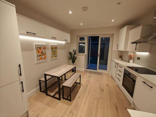 a kitchen with a table and a bench in it at Luxury 1-Bed Flat in Acton in London