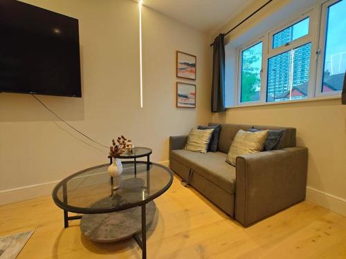a living room with a couch and a glass table at Luxury 1-Bed Flat in Acton in London
