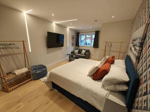 a bedroom with a bed and a flat screen tv at Luxury 1-Bed Flat in Acton in London