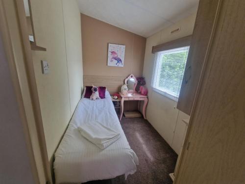 Una pequeña habitación con una cama y una ventana. en Lodge Sleeps 4 - Pet Friendly with Private Parking, en Barnstaple