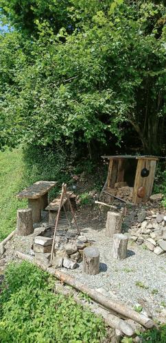 a picnic table and a grill with logs and a box at Panorama Jurte über dem Uri-See B in Sisikon
