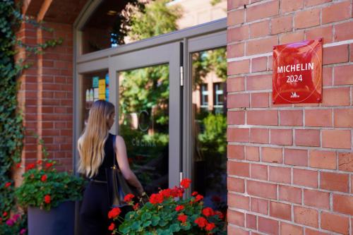 a woman is standing outside of a door at City Park Hotel & Residence in Poznań