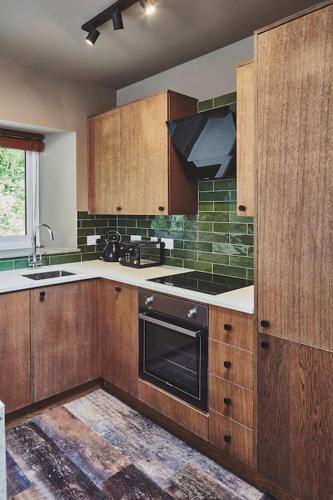 a kitchen with wooden cabinets and a stove top oven at Craig Chat in Oban