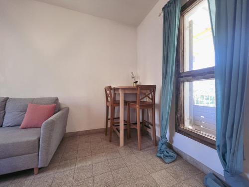 a living room with a table and a couch and a window at הצימר של יהושע in Ein Gedi