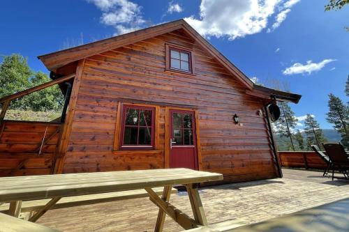 a wooden cabin with a picnic table in front of it at Ferienhaus in Vrådal Norwegen in Vradal