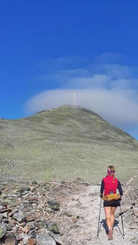 a woman walking up a mountain with ski poles at Ferienhaus in Vrådal Norwegen in Vradal