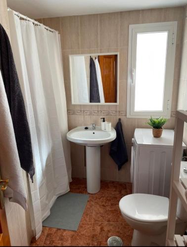 a bathroom with a sink and a toilet and a window at Torete in Roquetas de Mar