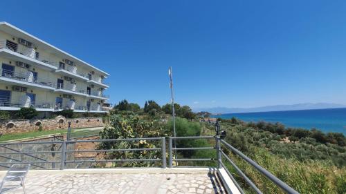 a building on top of a hill next to the ocean at De La Plage Hotel Koroni in Koroni