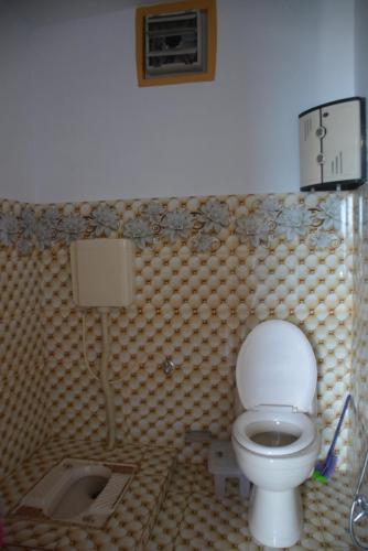 un baño con inodoro y lavabo en Mountain View Guest House by LMC, en Nathia Gali