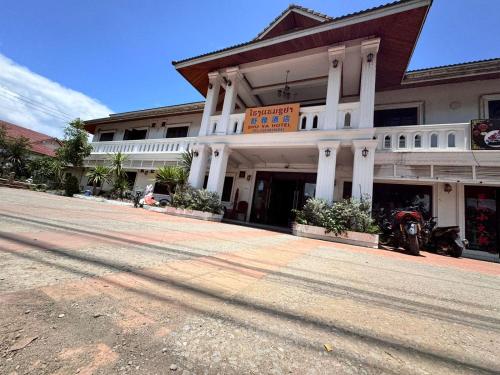 a building with a motorcycle parked in front of it at ShuYa Hotel 舒雅酒店 in Luang Prabang