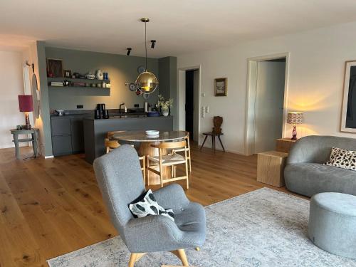 a living room with a couch and a table and a chair at Ferienwohnung Mühlbach in Breitbrunn am Chiemsee