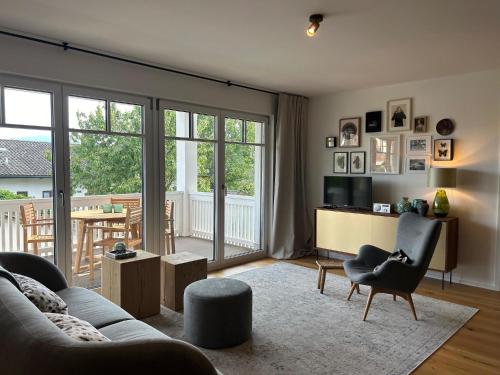 a living room with a couch and a chair and a television at Ferienwohnung Mühlbach in Breitbrunn am Chiemsee
