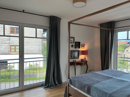 a bedroom with a bed and a large window at Ferienwohnung Mühlbach in Breitbrunn am Chiemsee