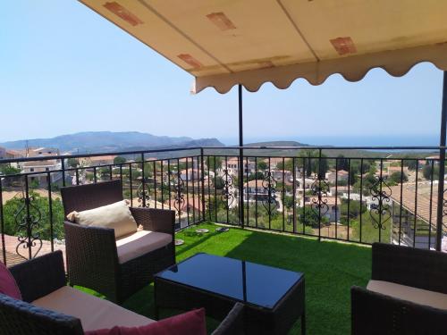 a balcony with chairs and a table and a view at Agnadema House in Lixouri