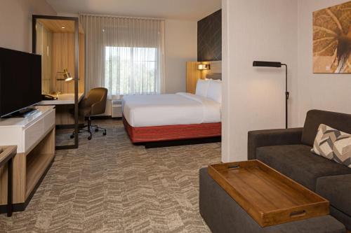a hotel room with a bed and a living room at SpringHill Suites by Marriott Turlock in Turlock