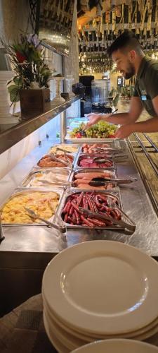 Ein Mann bereitet ein Buffet in einem Restaurant vor. in der Unterkunft Conacul Radacinilor in Petroşani