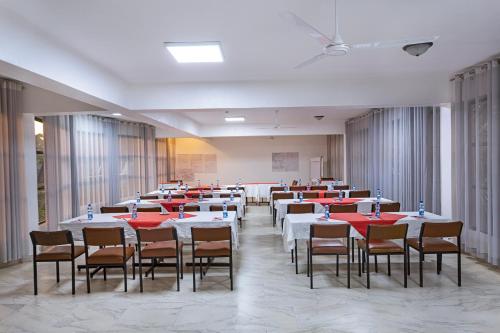 un comedor con mesas y sillas con mantel rojo en Roswam Hotel, en Keruguya