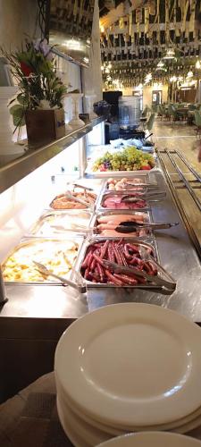 ein Buffet mit vielen verschiedenen Speisen in der Unterkunft Conacul Radacinilor in Petroşani