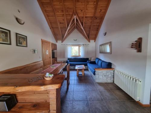 a living room with a blue couch and a table at Encanto del Rio in Villa La Angostura