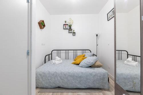 une chambre avec un lit et un miroir dans l'établissement Joli studio confortable, à Saint-Quentin