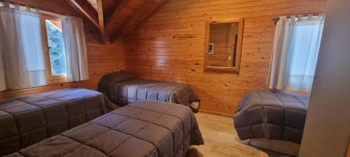 a room with three ottomans in a log cabin at Encanto del Rio in Villa La Angostura