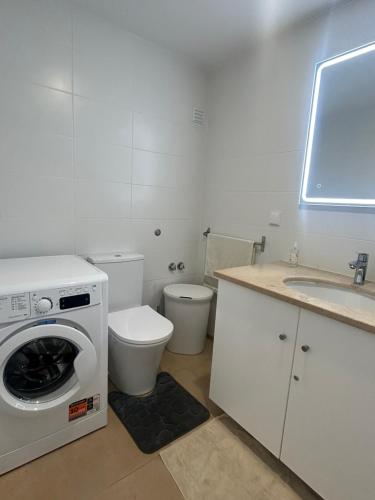 a bathroom with a washing machine and a toilet at Lido Casa by Olá Madeira in Funchal