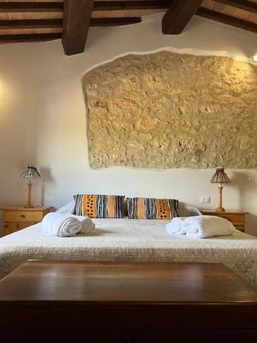 a bedroom with a bed with two pillows on it at Antica Fonte Eterna - Casale in incantevole contesto Toscano in Colle di Val d'Elsa