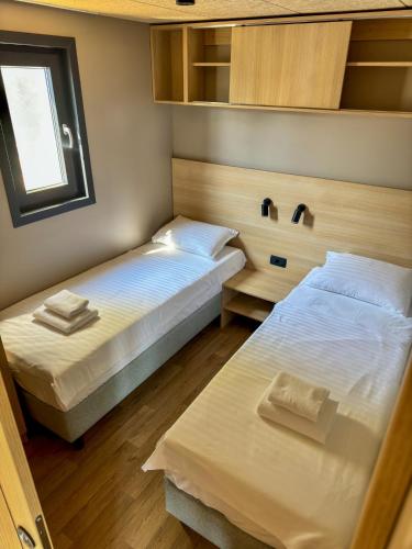 a room with two beds and a window at Holiday Home Ahil 10 in Pakoštane
