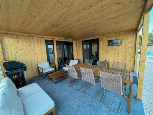a porch with a wooden table and chairs and a stove at Holiday Home Ahil 10 in Pakoštane