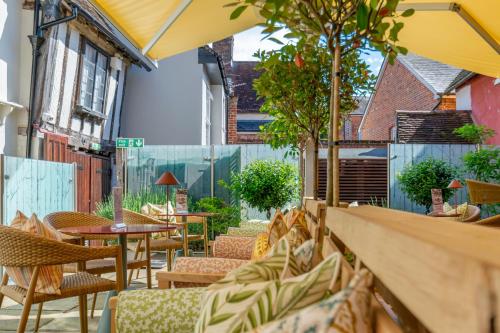 an outdoor seating area with tables and chairs at The Great House Lavenham Hotel & Restaurant in Lavenham