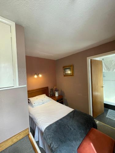 a small bedroom with a bed and a window at The Prince of Wales in Huntingdon