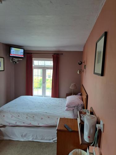 a bedroom with a large bed and a window at The Prince of Wales in Huntingdon
